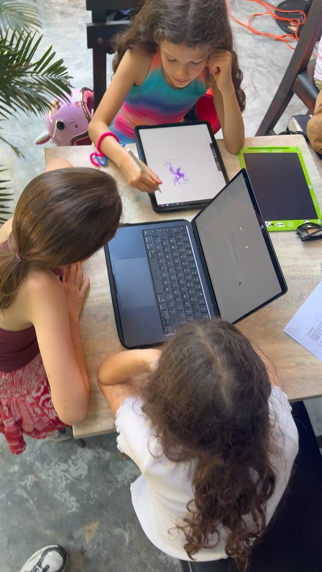Children prototyping with tablets and a laptop at a table in Hoi An